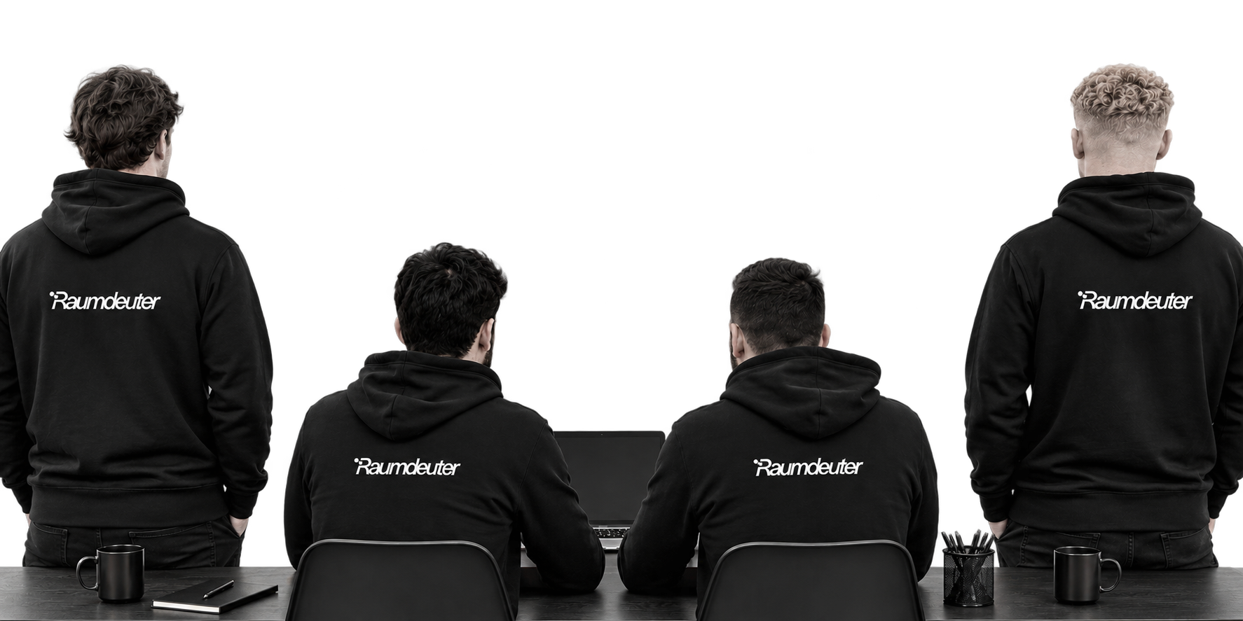 Das Raumdeuter-Team von hinten am Schreibtisch, zwei stehen außen, zwei sitzen am Laptop